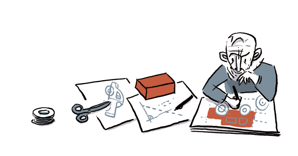 Michael Rosen working on a plan - constructing a toy car, concentrating hard.